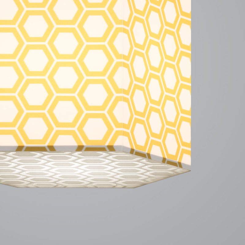 Lumetta's custom Hexagon Lite Pendant is shown with a yellow honeycomb Lumenate® diffuser and a etched honeycomb white acrylic bottom lens.