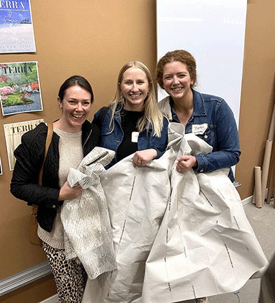 McGovern Design Team pose with their gown material following the grab and go for the IIDA Fashion Show 2024