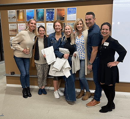 McGovern Design Team and OSC Representative Hallie Putterman pose in front of the Design Influencer Board for the IIDA Fashion Show 2024